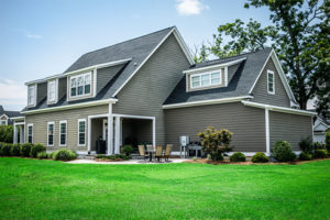 Evolution grass seed results in lush green lawn shown here in yard of green cape cod style home